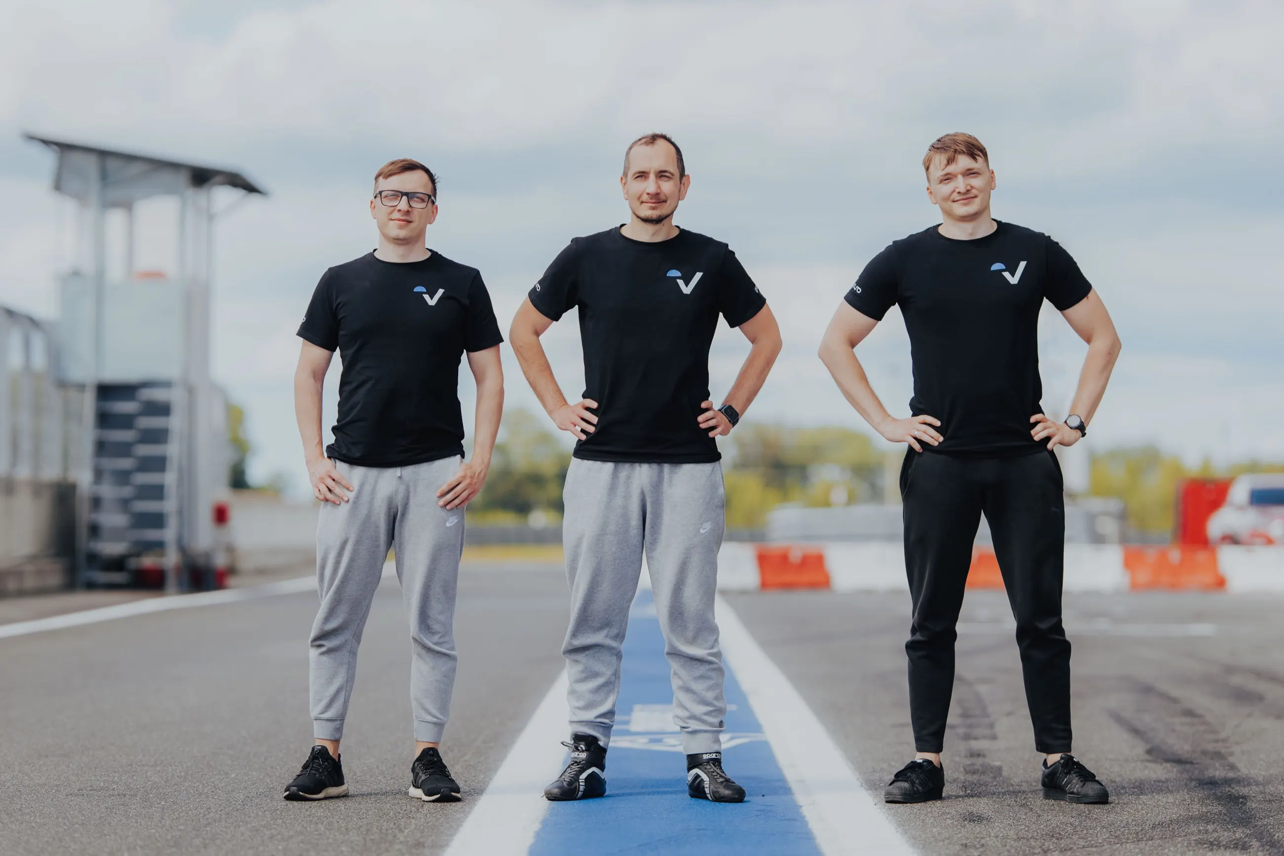 Od lewej: Daniel Niżyński, Paweł Sobociński i Kornel Kwiatkowski w czarnych koszulkach z logo na torze